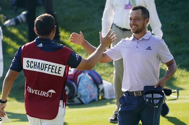 잰더 쇼플리(오른쪽)가 27일 미국 코네티컷주 크롬웰의 TPC 하이랜즈에서 열린 PGA 투어 트래블러스 챔피언십을 버디로 마무리하면서 캐디와 우승을 축하하고 있다. 크롬웰｜AP연햡뉴스