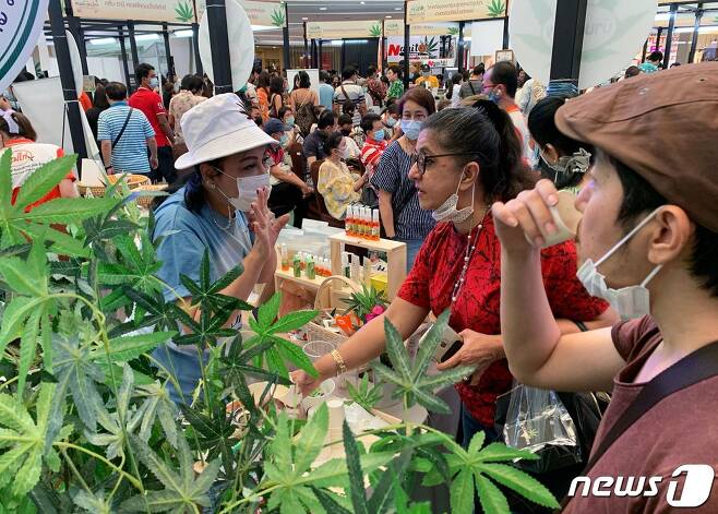 쇼핑객들이 2021년 3월 21일(현지시간) 태국 방콕 쇼핑몰에서 열린 무역 박람회에서 대마초 잎이 들어가 있는 차 샘플을 마시고 있다. © AFP=뉴스1 © News1 김지현 기자