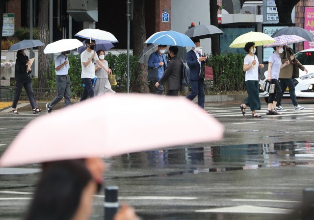 본격적인 장마철이 시작된 27일 서울 여의도역 인근에서 우산을 쓴 시민들이 이동하고 있다. 뉴스1