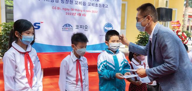 LS VINA 김종필 법인장이 지난 4월 개최된 LS드림스쿨 17호 준공식에서 베트남 초등학생에게 장학금을 수여하고 있다.