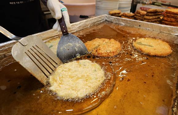 비가 많이 내리는 장마철에는 빈대떡집과 수제비집 방문이 늘었다는 카드 소비 분석결과가 나왔다. 사진은 서울 종로구 광장시장 내 빈대떡 매장에서 빈대떡을 부치는 모습./사진=뉴스1