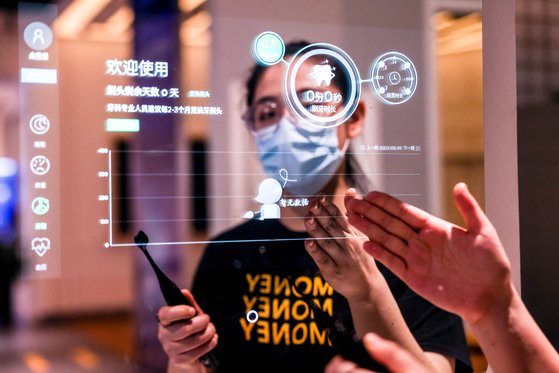 한·중간 산업 경쟁력 격차가 줄고 있다. 사진은 지난 5월 중국에서 열린 ‘2022 국제 빅데이터 산업 엑스포’에서 한 직원이 스마트 거울을 소개하는 모습. [중국 신화망 캡처]