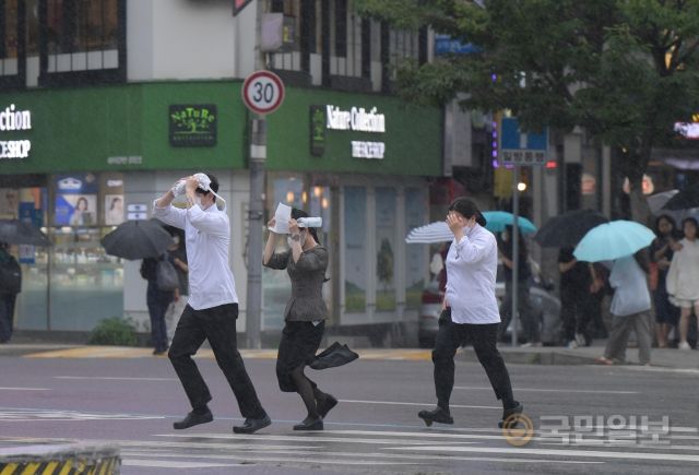 서울지역에 장맛비가 내린 29일 광화문 사거리에서 시민들이 비를 피해 횡단보도를 건너고 있다.