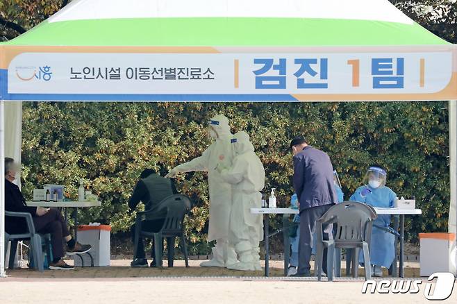 (시흥=뉴스1) 조태형 기자 = 방역당국이 요양병원·시설, 정신병원에 대한 신종 코로나바이러스 감염증(코로나19) 전수검사 중인 20일 오전 경기도 시흥시 포동시민운동장에 마련된 노인시설 이동선별진료소에서 보건소 관계자들이 검체 채취를 하고 있다. 사진은 기사 내용과 무관. 2020.10.20/뉴스1