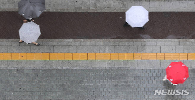 [서울=뉴시스] 백동현 기자 = 비가 내리는 27일 오후 서울 중구 세종대로에서 시민들이 우산을 쓰고 이동하고 있다. 2022.06.27. livertrent@newsis.com