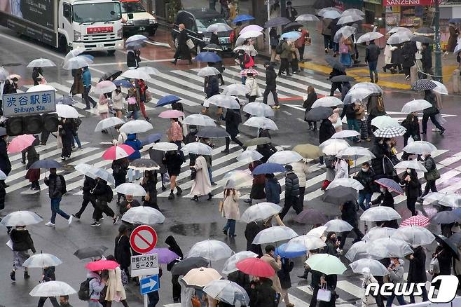 13일(현지시간) 코로나19 확산 속 일본 도쿄의 비 내리는 시부야 교차로에서 시민들이 우산을 쓰고 걸어가고 있다. © AFP=뉴스1 © News1 우동명 기자