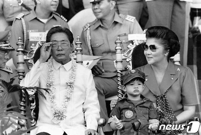 1985년 11월 페르디난드 마르코스 전 필리핀 대통령과 그의 부인 이멜다, 아들 마르코스 주니어가 대학생들의 군사훈련 모습을 지켜보고 있다. © AFP=뉴스1 © News1 강민경 기자