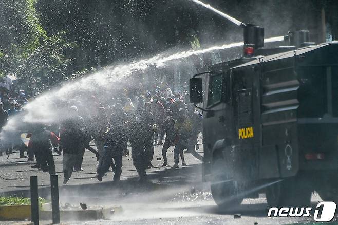 22일(현지시간) 에콰도르 키토에서 진압 경찰이 기름값 인상에 항의하는 시위대를 향해 물대포를 쏘고 있다. © AFP=뉴스1 © News1 우동명 기자