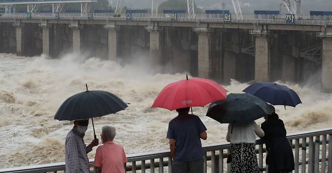 집중호우가 내린 30일 오후 경기 하남 팔당댐을 찾은 시민들이 댐 수문을 열어 하류로 물을 방류하는 모습을 지켜보고 있다. 김정효 기자
