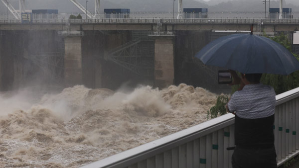 팔당댐 근처에서 한 시민이 집중호우로 방류 중인 댐을 보고 있다 [사진 제공: 연합뉴스]