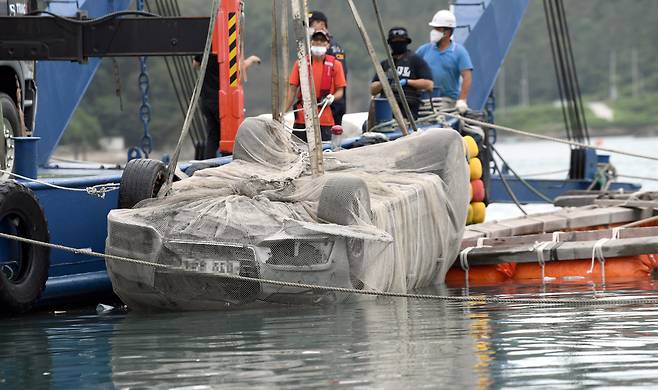 The police pulls a submerged car which belonged to Cho`s family off the shores of Wando, South Jeolla Province, Wednesday. (Yonhap)