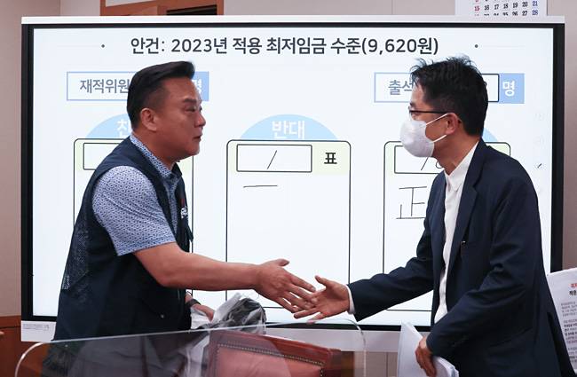 세종시 정부세종청사 최저임금위원회 회의실에서 29일 열린 제8차 최임위 전원회의에서 내년도 최저임금이 9620원으로 의결된 뒤 30일 새벽 근로자 위원인 이동호 한국노총 사무총장(왼쪽)과 박준식 위원장이 악수를 하고 있다. 연합뉴스