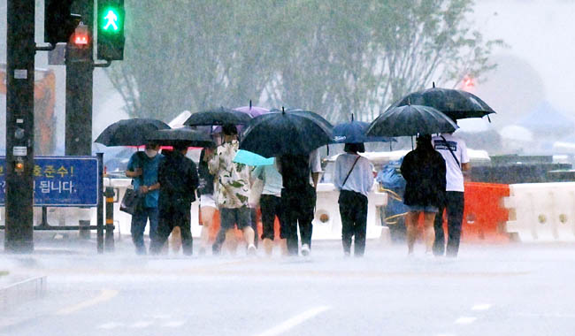 호우경보가 내려진 30일 오전 서울 광화문네거리에서 시민들이 우산으로 쏟아지는 비를 막으며 출근하고 있다.윤성호 기자