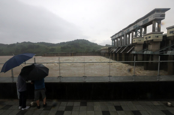 경기 연천군 주민들이 호우주의보가 내려진 30일 군남홍수조절댐 수문이 열려 방류하는 모습을 지켜보고 있다.뉴시스
