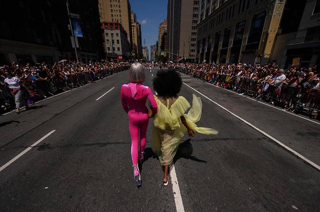 26일 미국 뉴욕에서 열린 2022 뉴욕 프라이드 페레이드의 한 장면. 동성애자로 보이는 두 참가자가 팔짱을 끼고 거리를 걷고 있다./AFP 연합뉴스