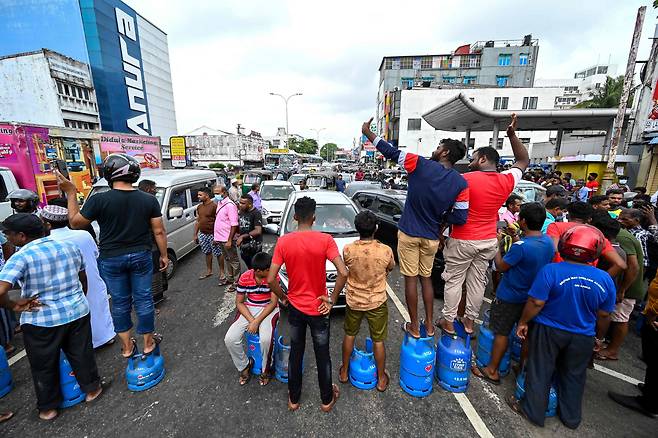 스리랑카 수도 콜롬보 시내에서 가스통 충전을 기다리는 주민들이 긴 행렬을 이루며 주변 교차로 통행을 막고 있다.