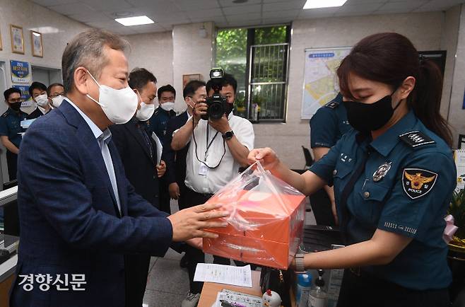 이상민 행정안전부 장관(왼쪽)이 1일 오후 서울 마포구 서울마포경찰서 홍익지구대를 방문해 경찰관들에게 프랜차이즈 도넛 2박스를 전달하고 있다. 한수빈 기자
