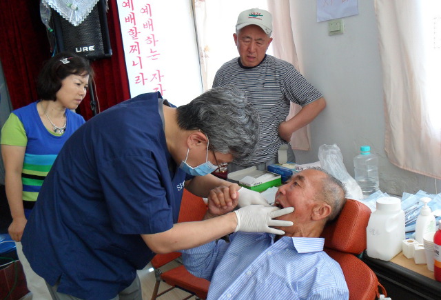 중국 지린성 투먼시에서 교인과 함께 의료 봉사활동을 하는 김 대표(왼쪽).
