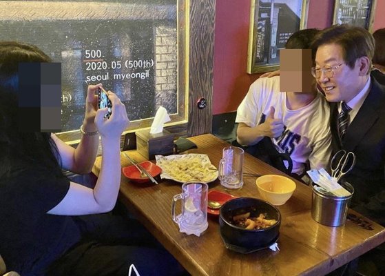 이재명 더불어민주당 의원이 지난달 29일 자신의 지역구인 인천 계양구의 한 음식점에서 시민들과 만나 기념사진을 찍고 있다. [이재명 의원 트위터 캡처]