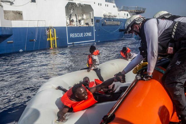 '국경 없는 의사회' 소속 구호대원들이 지난 27일 리비아 앞바다에서 침몰 중인 난민 보트에서 생존자들을 구조하고 있다. 연합뉴스