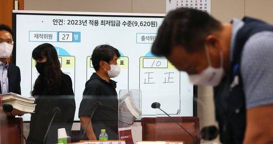 지난달 30일 오전 세종시 정부세종청사 최저임금위원회 회의실에서 열린 제8차 전원회의에서 내년도 최저임금을 9천620원으로 결정됐다. 근로자 위원인 이동호 한국노총 사무총장(오른쪽)이 고민하는 표정을 하고 있고, 공익위원(왼쪽)들은 회의장을 나서고 있다. 연합뉴스