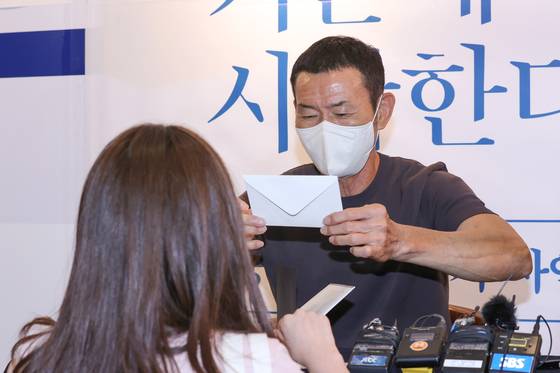 편지 받는 손웅정 감독 (서울=연합뉴스) 신현우 기자 = 손흥민 선수의 아버지인 손웅정 SON축구아카데미 감독이 7일 오전 서울 종로구 교보문고 광화문점에서 열린 저자 사인회에서 팬으로부터 편지를 받고 있다. 손웅정 감독은 지난해 10월 자서전 '모든 것은 기본에서 시작한다'를 펴낸 바 있다. 2022.7.7 nowwego@yna.co.kr (끝) 〈저작권자(c) 연합뉴스, 무단 전재-재배포 금지〉