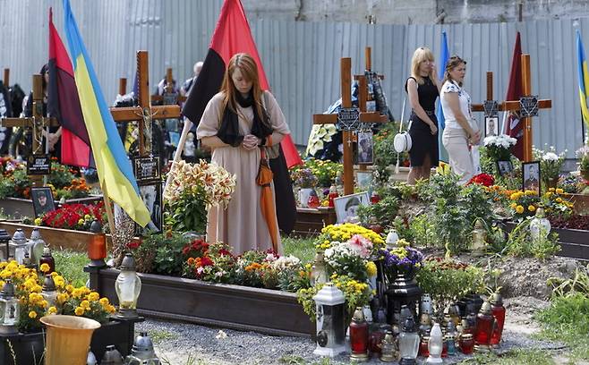 28일(현지시각) 우크라이나 서부 르비우의 군인 묘지에서 시민들이 우크라이나 영토를 지키다가 숨진 전사자 추모 행사를 열고 있다. 르비우/EPA 연합뉴스