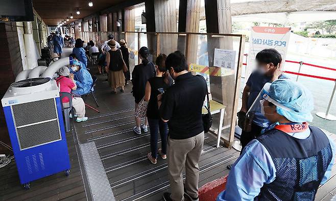 5일 오전 서울 송파구보건소 선별진료소를 찾은 시민들이 코로나19 검사를 받기 위해 대기하고 있다. 뉴시스