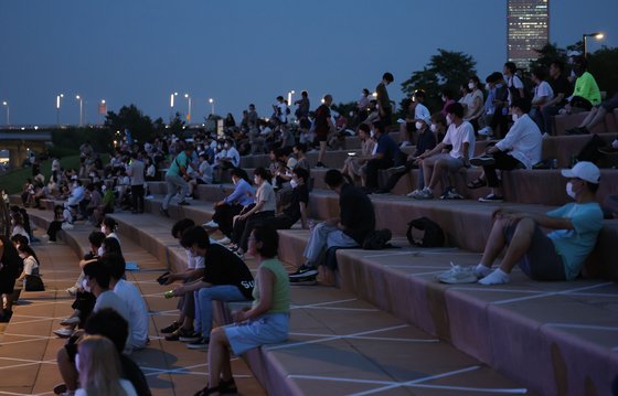 지난달 29일 오후 열대야를 피해 서울 여의도 한강공원을 찾은 시민들이 물빛무대에서 열린 한강썸머뮤직피크닉 공연을 관람하고 있다. 연합뉴스