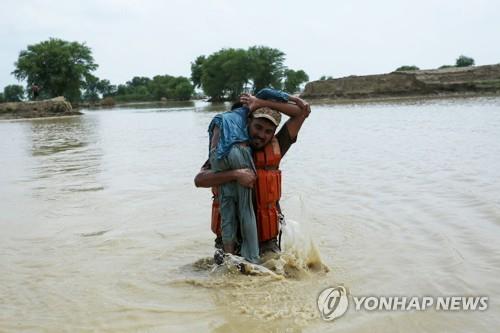 파키스탄 홍수 (라잔푸르[파키스탄] AFP=연합뉴스) 2일(현지시간) 파키스탄 펀자브 지방 라잔푸르 지역에서 파키스탄 군인이 홍수 피해를 입은 어린이를 구출하고 있다. 2022.8.6 photo@yna.co.kr