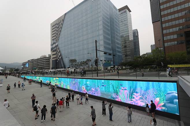 6일 오후 서울 광화문광장 해치마당 한쪽 벽면에 설치된 디스플레이 창이 시민들의 눈길을 끌고 있다. 강창광 선임기자
