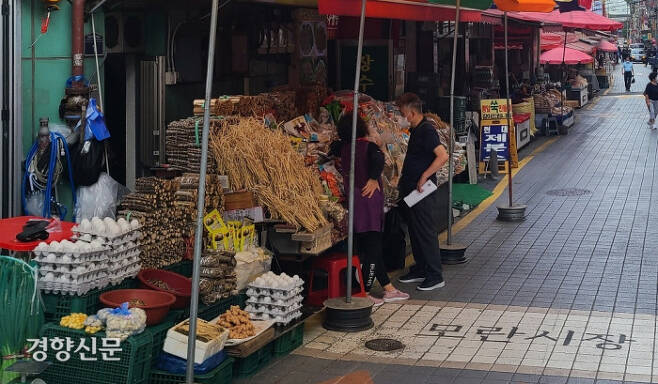 경기 성남시 모란시장을 찾은 시민이 지난 5일 물건을 사기 위해 상인과 대화를 나누고 있다.