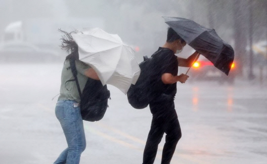 장마가 다시 시작된 8일 오후 서울 영등포구의 한 횡단보도에서 우산을 쓴 시민들이 길을 건너고 있다. 사진=연합뉴스