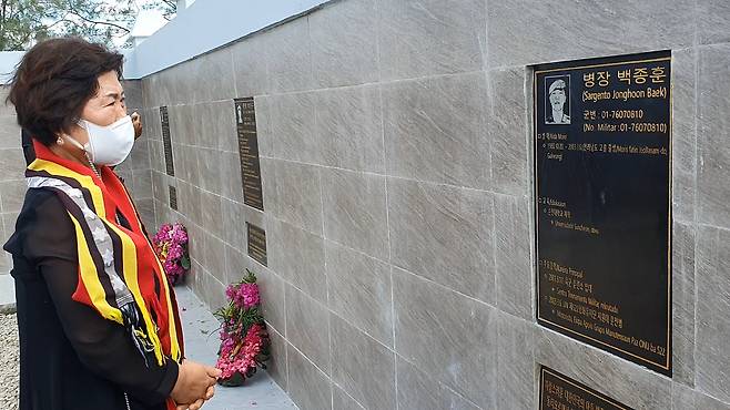 지난 4일 동티모르 오에쿠시주(州) 에카트 강 인근에 세워진 상록수부대 순직 장병 추모공원 준공식에서 故 백종훈 병장의 모친 김순심 여사가 헌화 후 아들의 얼굴을 바라보고 있다. (오에쿠시=민소영 기자)