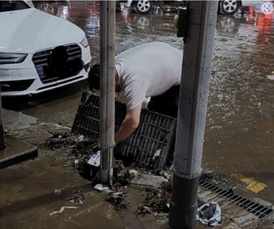 서울 강남구 강남역 인근 도로에서 한 남성이 배수관을 맨손으로 정리하는 모습. 사진=온라인 커뮤니티 갈무리