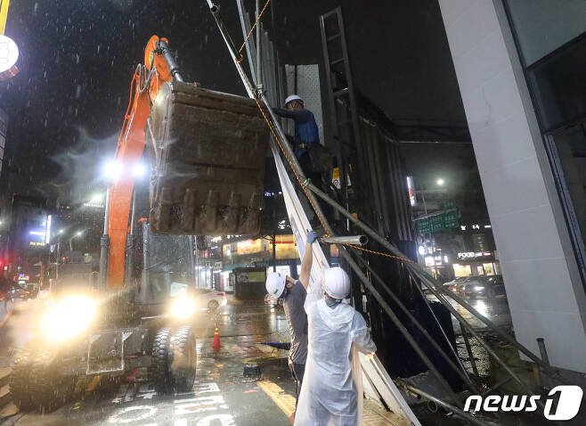 폭우가 내린 8일 오후 서울 중구 약수역 인근 공사현장에 가림판이 쓰러져 관계자들이 정리작업을 하고 있다. 2022.8.8/뉴스1 ⓒ News1 송원영 기자