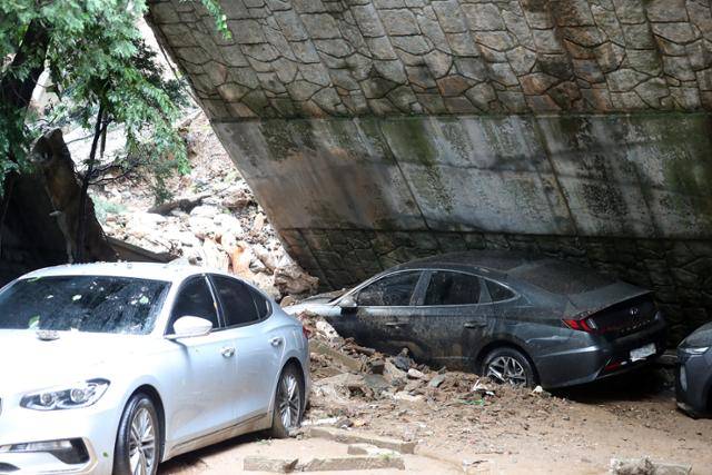 폭우로 피해가 발생한 9일 오전 서울 동작구 사당동의 한 아파트 인근 축대가 붕괴돼 차량이 파손되어 있다. 뉴시스