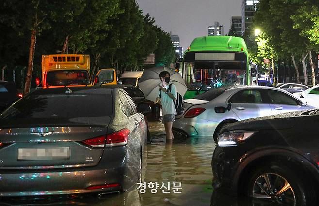 서울에 집중호우가 내린 지난 8일 밤 서울 대치역 인근 도로가 침수된 후 한 시민이 물에 잠긴 차량들을 바라보고 있다. /성동훈 기자
