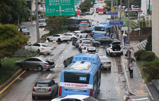 서울 서초구 진흥아파트 앞 서초대로 일대에서 9일 오전 폭우로 침수됐던 차량들이 모습을 드러내고 있다. 연합뉴스