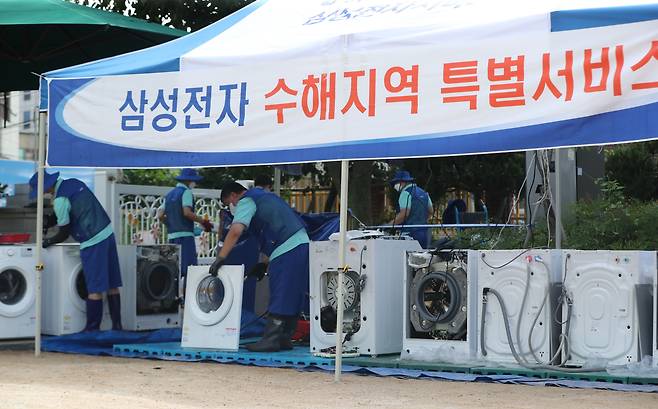 삼성전자 서비스센터 직원들이 11일 오후 서울 관악구 남부초등학교에 마련된 '침수피해주민 가전제품 무료수리 서비스 부스'에서 가전제품을 수리하고 있다. /뉴스1