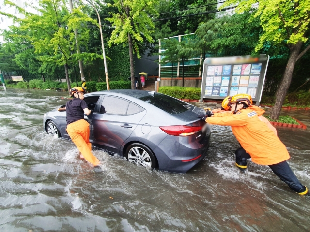 지난 8일 오후 인천에 강하게 내린 비로 인해 미추홀구 용현동 한 도로에서 차량이 침수돼 신고를 받고 출동한 소방당국이 안전조치를 하고 있다. 인천소방본부 제공