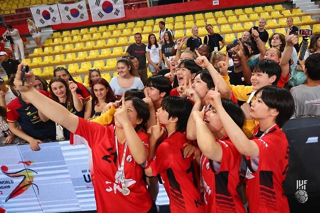 ▲ 북마케도니아 현지에서 한국을 응원한 팬들과 기념촬영하는 한국 청소년 여자 핸드볼 대표팀 ⓒIHF 홈페이지