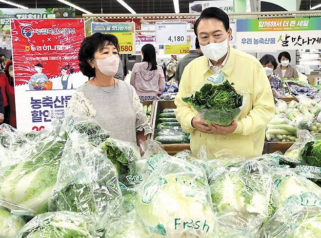 윤석열 대통령이 11일 서울 서초구 양재동 하나로마트 양재점 채소 판매매장을 둘러보고 있다. 윤 대통령은 “장바구니 물가를 확실하게 잡겠다”고 말했다. /연합뉴스