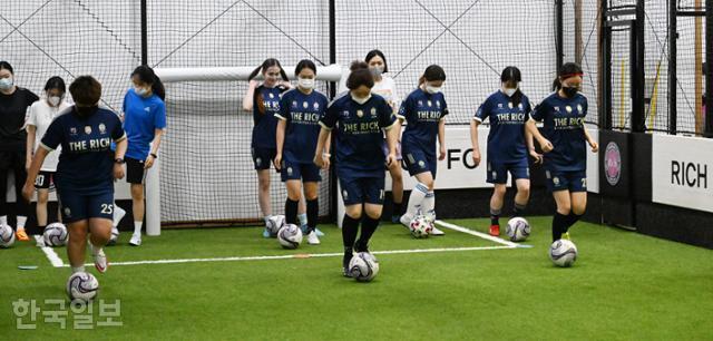 지난 8일 오후 8시 구로구의 FC리치축구클럽에서 직장인 여성 회원들이 공을 드리블하며 전진하고 있다. 고영권 기자