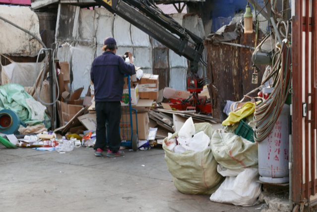 한 노인이 고물상에 재활용품을 판매하기 위해 무게를 측정하고 있다. 최종재생업체가 매입가를 결정하면, 중간 업체가 이윤을 뺀 가격을 고물상에 제시하고, 고물상은 여기서 자신의 이윤을 뺀 가격을 노인들에게 제시한다. 재활용품의 가격은 최종재생업체가 결정하는 셈이다. 촬영 소준철
