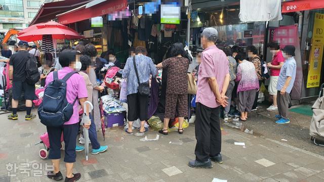 13일 오후 서울 동작구 남성사계시장의 한 옷가게에 사람들이 모여 있다. 김도형 기자