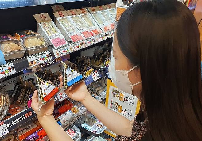 고객이 이마트24 매장에서 더빅삼각김밥을 구입하고 있다. / 이마트24 제공