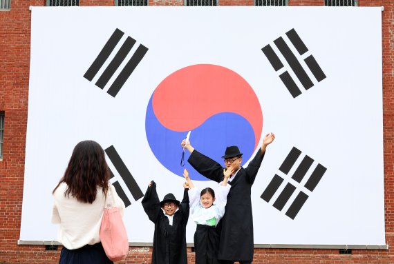 광복절 77주년을 하루 앞둔 14일 오전 시민들이 서울 서대문형무소역사관 앞 대형 태극기 앞에서 사진을 찍고 있다. 사진=서동일 기자