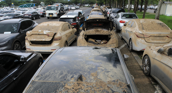 Cars damaged by last week’s heavy rains are parked outside Seoul Grand Park in Gwacheon, Gyeonggi, on Sunday afternoon to receive insurance benefits. The General Insurance Association of Korea announced that at least 9,189 cars have been reported to 12 property insurance companies for damages expected to be worth about 127.37 billion won ($97.8 million). [NEWS1]