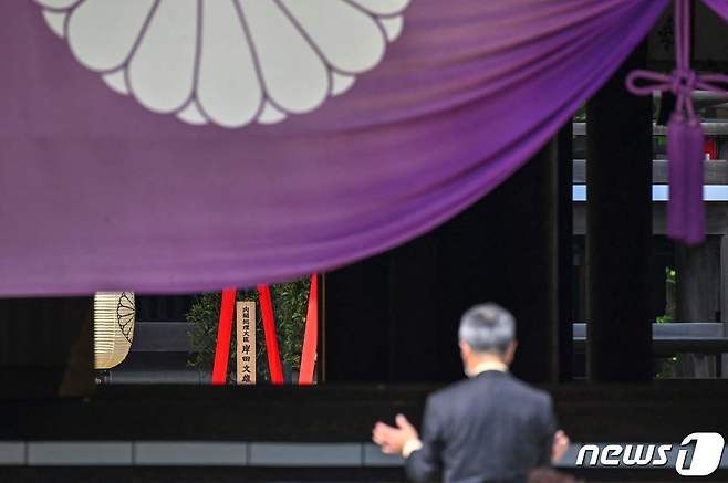 21일 (현지시간) 도쿄 야스쿠니 신사의 춘계 예대제 첫날에 기시다 후미오 일본 총리가 봉납한 공물 '마사카키' 앞에서 주민이 기원을 하고 있다. ⓒ AFP=뉴스1 ⓒ News1 우동명 기자
